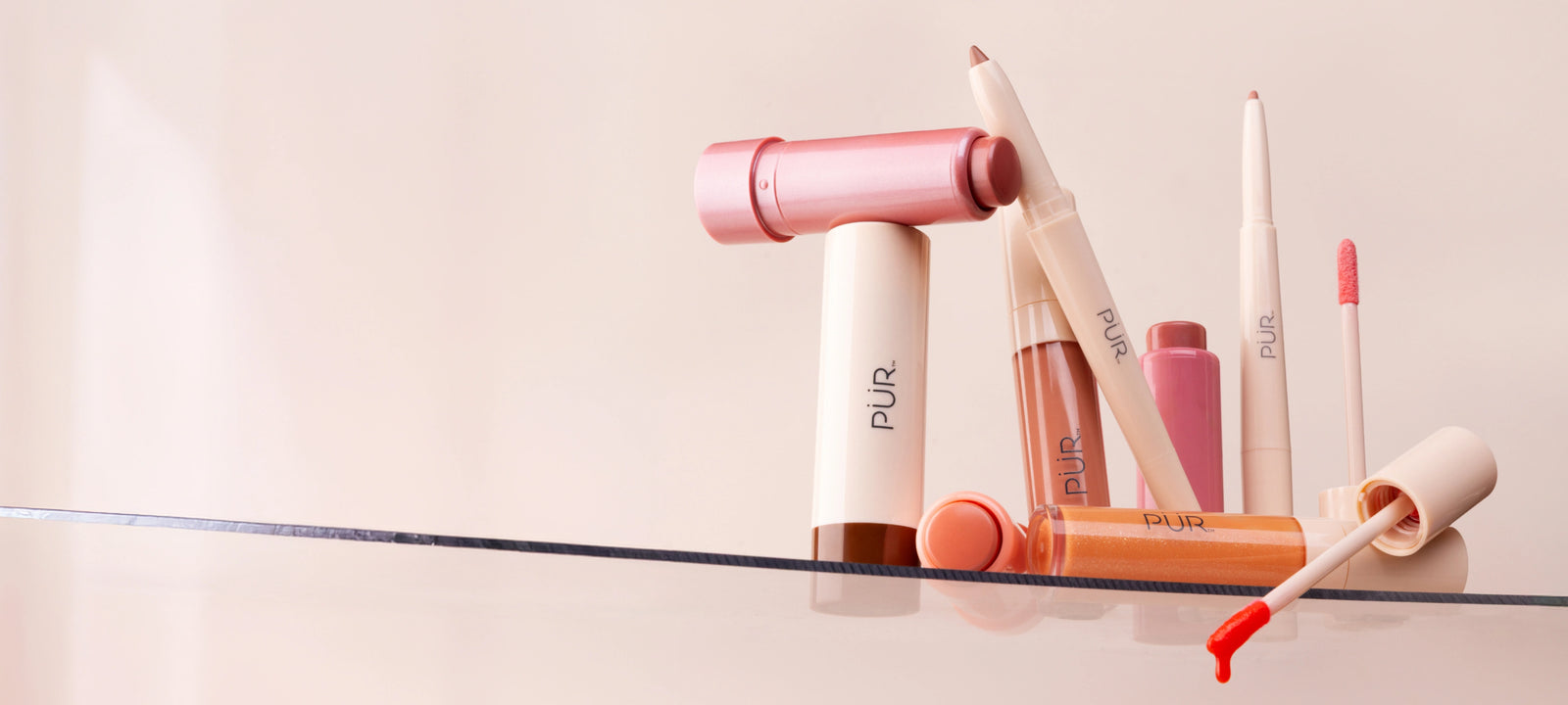 National Lipstick Day: 40% Off Lipstick - Various lip makeup products on glass shelf against pale pink background (desktop)
