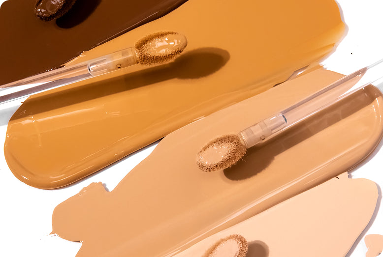 Close up of complexion product Love Your Selfie and Doe Applicator against four color swatch background