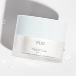 PÜR Cloud Cream jar shown with water droplets to emphasize lightweight hydration and moisture-rich texture.